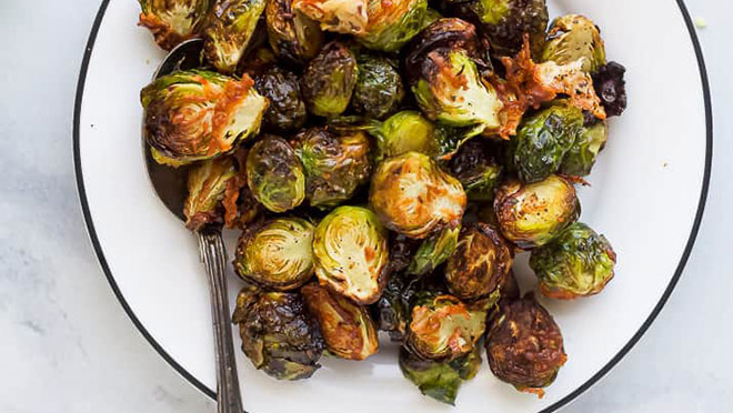 A bowl of parmesan garlic brussel sprouts made in an air fryer A bowl of parmesan garlic brussel sprouts made in an air fryer