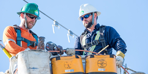 Two power line technicians on a bucket truck.