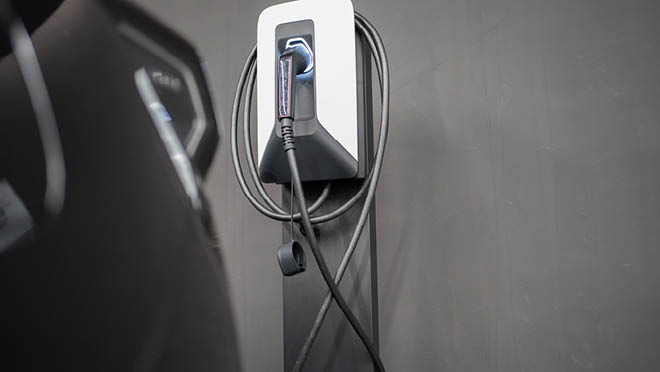 Electric vehicle charger plug on gray wall Electric vehicle charger plug on gray wall